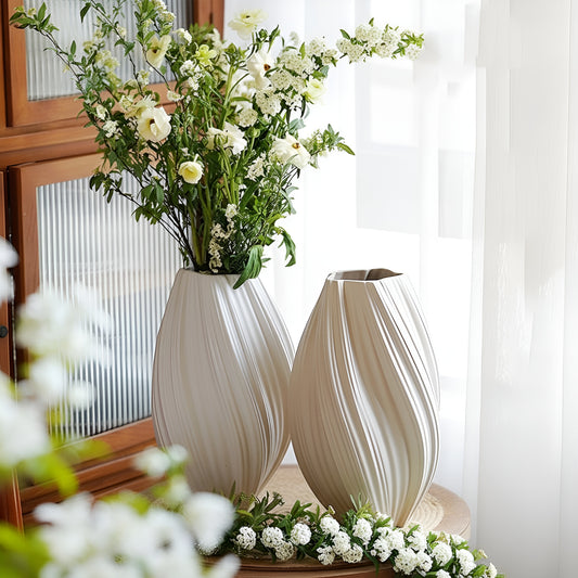 Two decorative vases with a bouquet of flowers on a table.