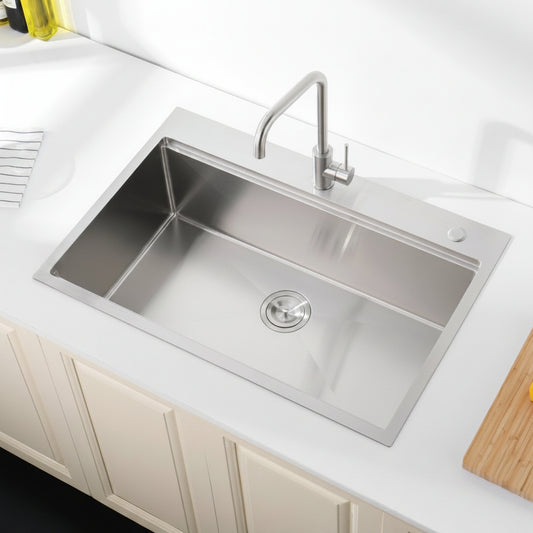Stainless steel kitchen sink with faucet on a white countertop