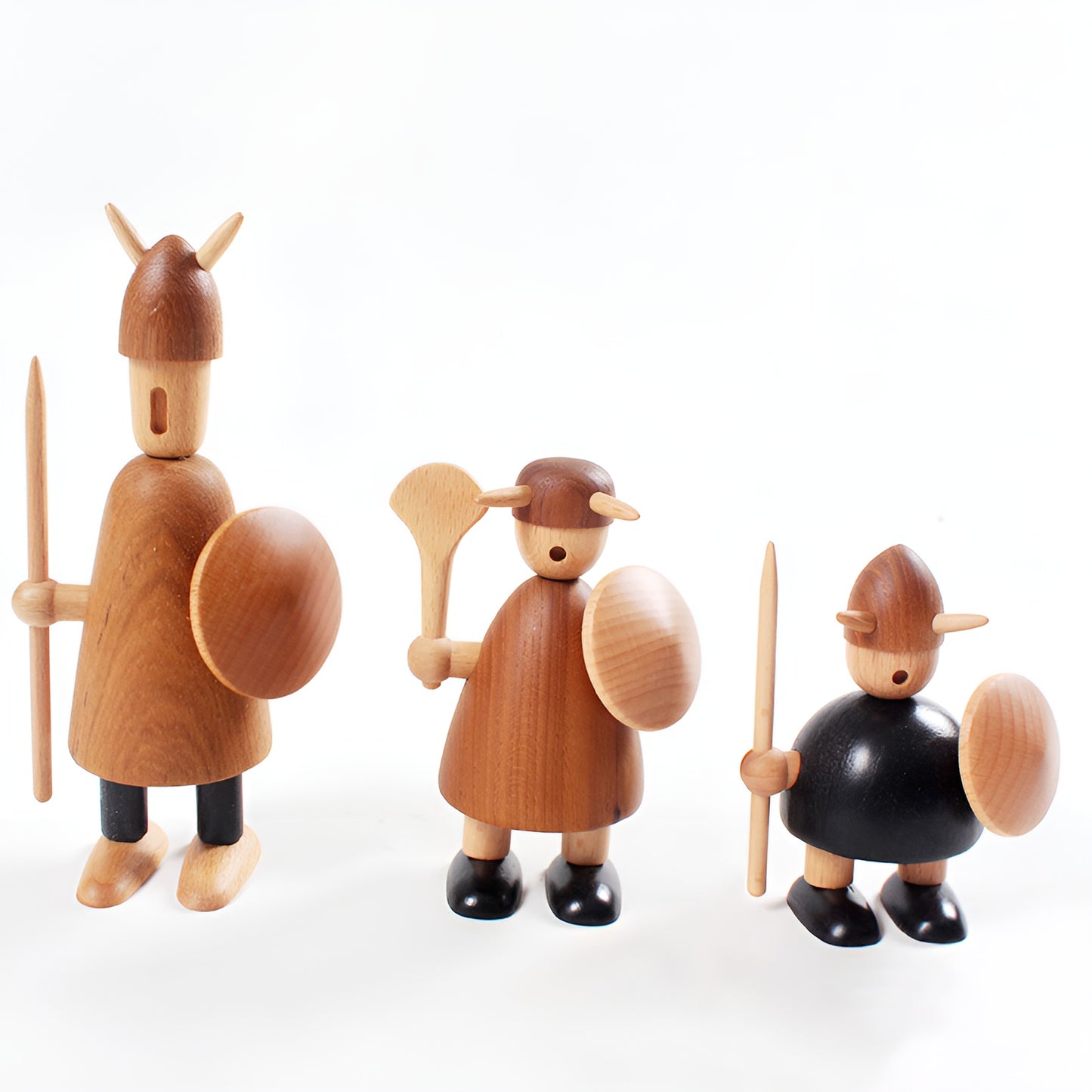 Three wooden figurines of warriors on a white background