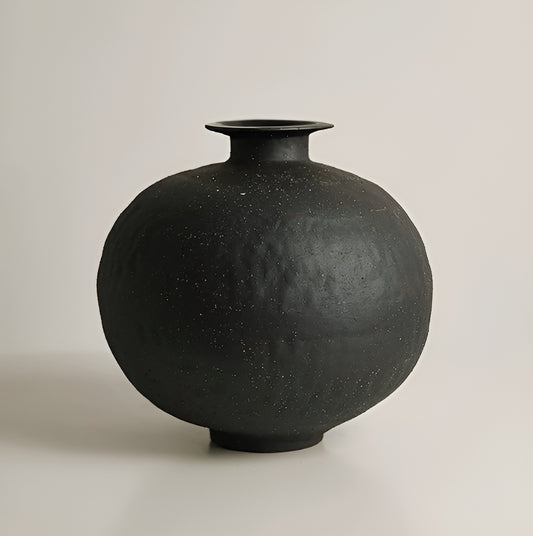 Black ceramic vase on a light gray background