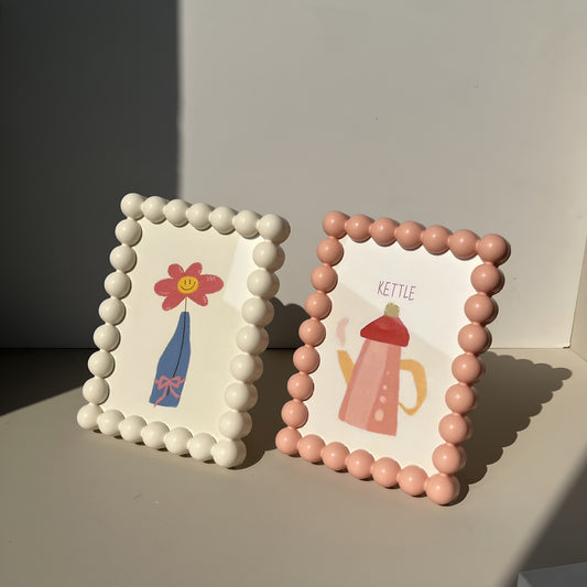 Two decorative picture frames with illustrations on a plain background